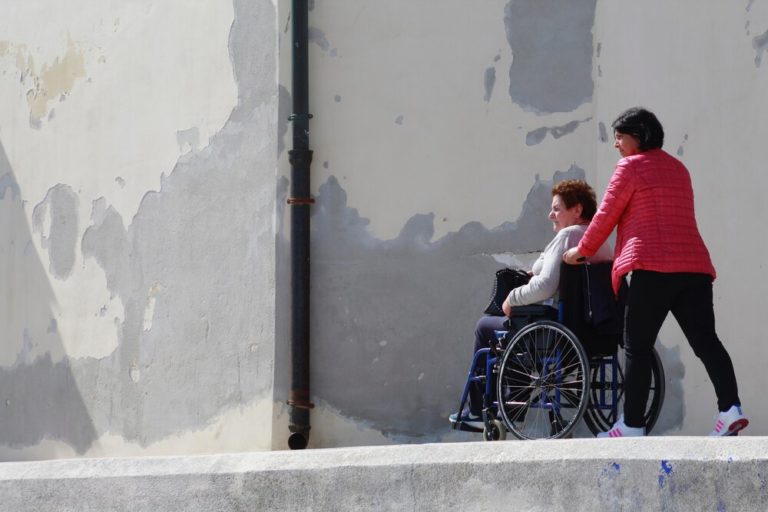 A women pushing another women in a wheelchair